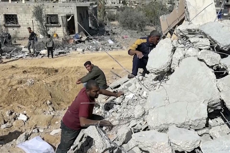 Palestinians sift through the rubble of a building destroyed by Israeli air strikes in the city of Khan Younis, southern Gaza Strip (AP)