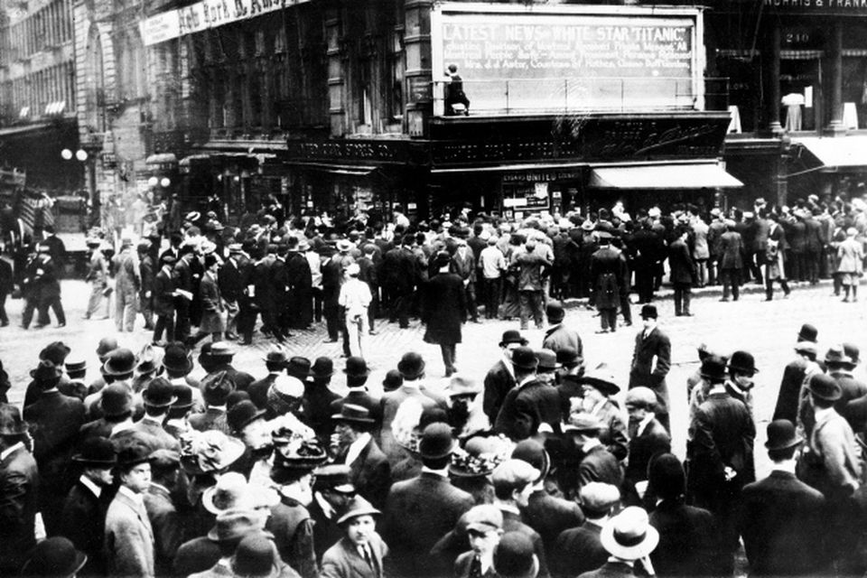 Crowds gather around the bulletin board of the New York American newspaper in New York, where the names of people rescued from the sinking Titanic are displayed.