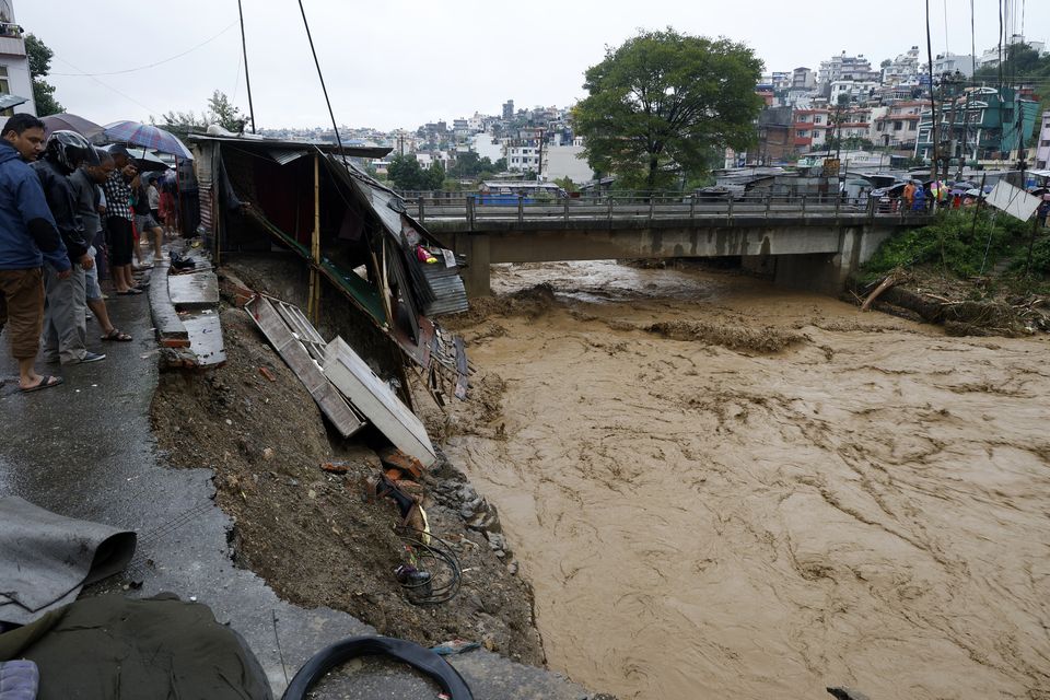 People gather at the edge of the Bagmati River in Kathmandu (Gopen Rai/AP)