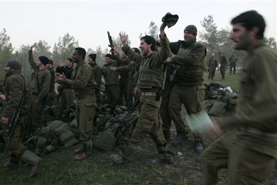 Israeli reserve soldiers rejoice as they see others crossing back into Israel from a combat mission in the Gaza Strip, Monday, Jan. 12, 2009. Israeli warplanes pounded the homes of Hamas leaders in the Gaza Strip and ground troops edged ever closer to the territory's densely-populated urban center Monday but reported casualties were low, an indication that Hamas was largely avoiding pitched battles with the advancing Israelis. (AP Photo/Lefteris Pitarakis)