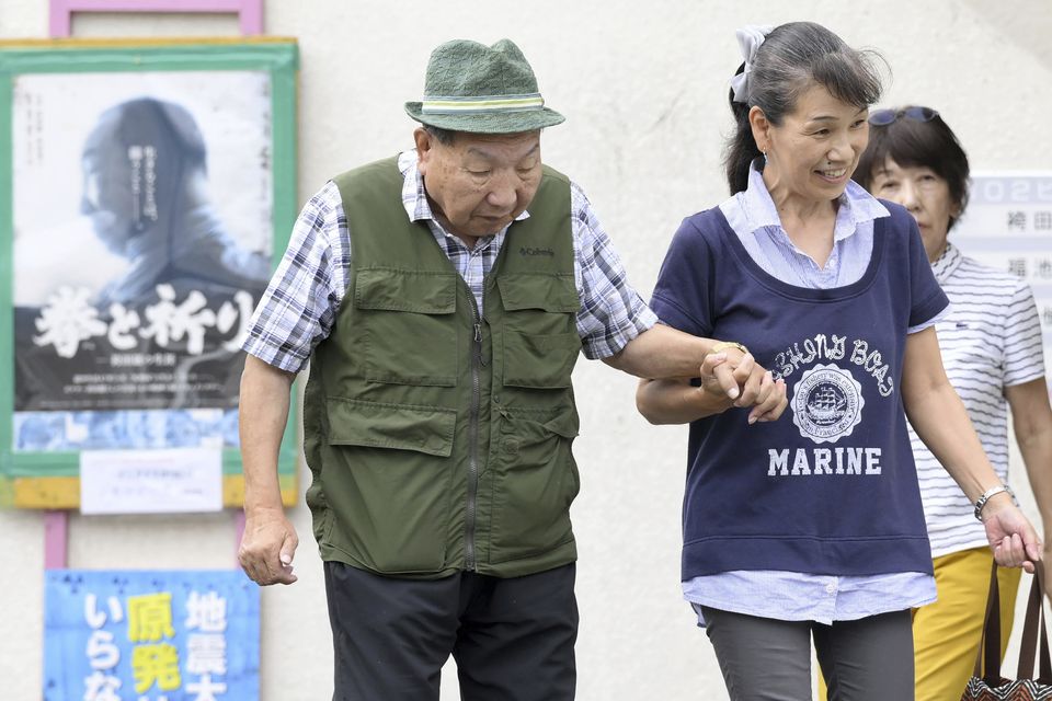 Iwao Hakamada is helped by a supporter as he goes for a walk in Hamamatsu in Shizuoka prefecture, central Japan (Kyodo News/AP)