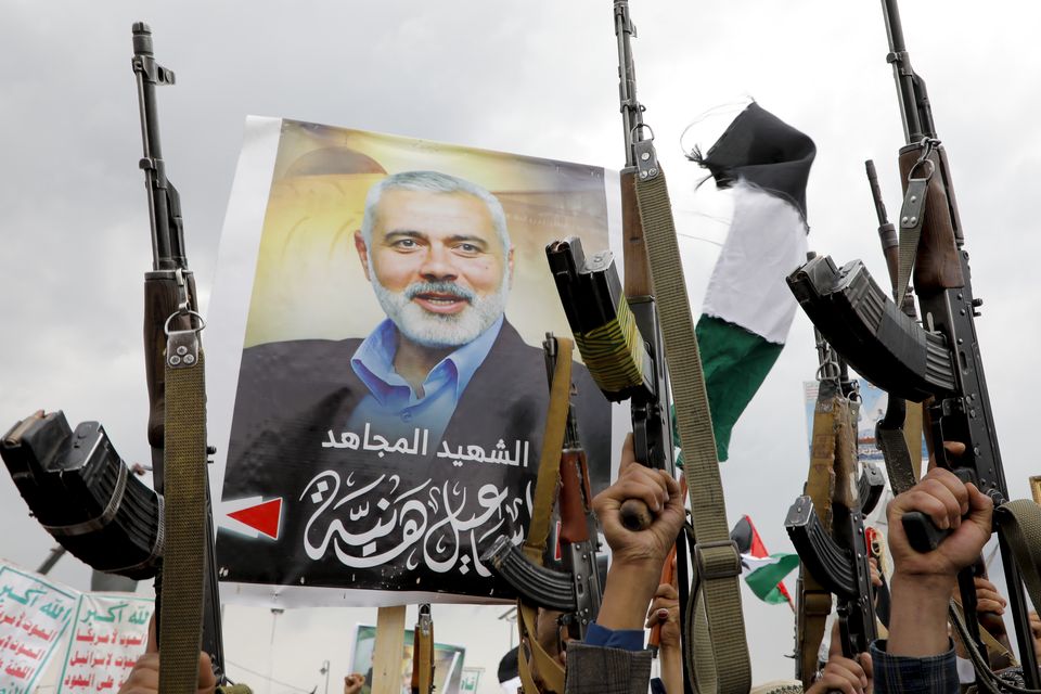 Yemeni protesters raise their machine guns during a protest to condemn the killing of Hamas leader Ismail Haniyeh (Osamah Abdulrahman/AP)