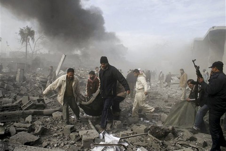 Palestinians carry the body of a Palestinan from the rubble following an Israeli missile strike in Rafah, southern Gaza Strip, Saturday, Dec. 27, 2008.Israeli warplanes demolished dozens of Hamas security compounds across Gaza on Saturday in unprecedented waves of simultaneous air strikes. Gaza medics said more than 120 people were killed and more than 250 wounded.(AP Photo/Hatem Omar)