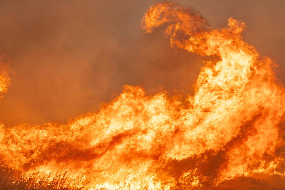 Jaime Hernandez sprays water to defend his home while battling approaching flames from the Mountain Fire (Stephen Lam/San Francisco Chronicle via AP)