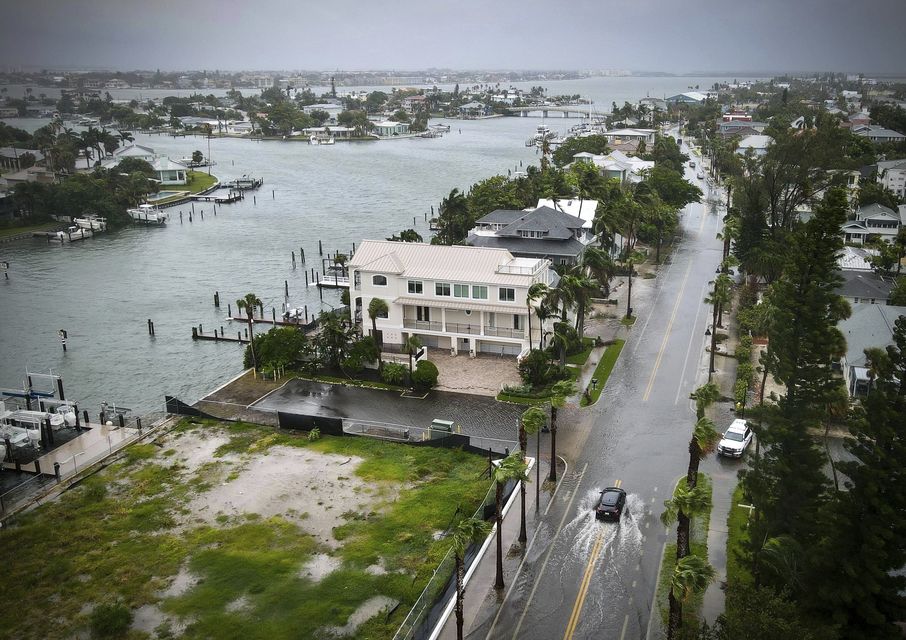 A driver negotiates a flooded street (Max Chesnes/Tampa Bay Times via AP)