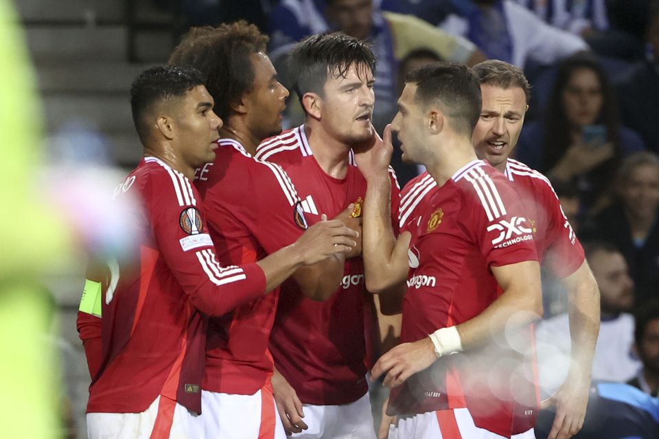 Harry Maguire, centre, celebrates his equaliser against Porto (Luis Vieira/AP)