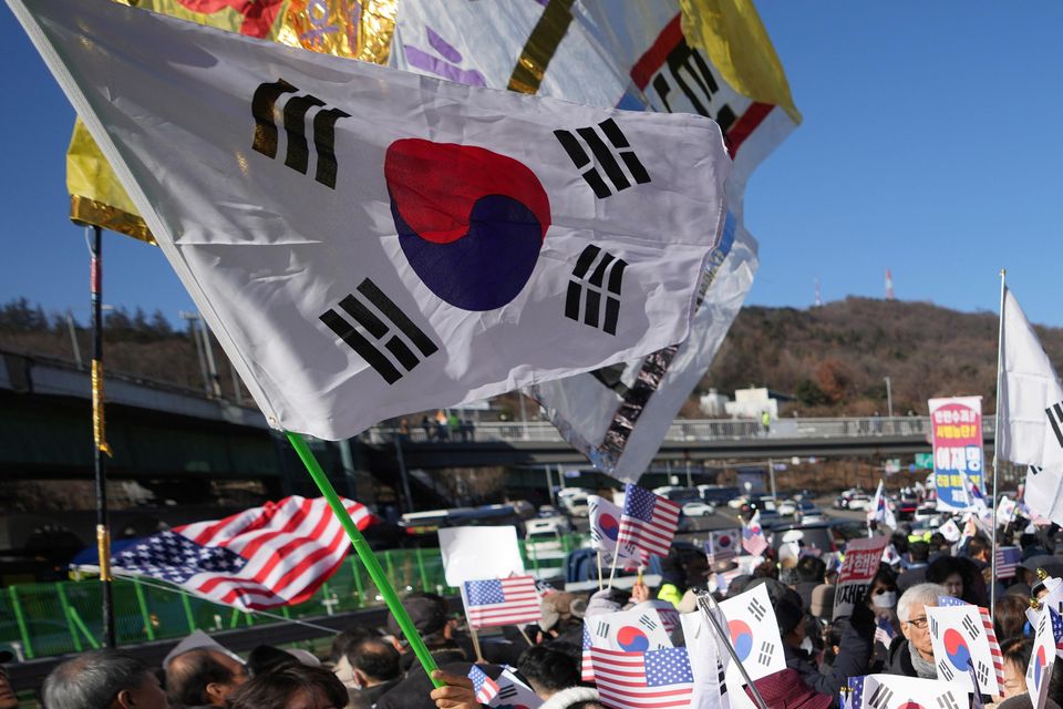 Supporters of impeached South Korean President Yoon Suk Yeol stage a rally after hearing news that a court issued warrants to detain Mr Yoon (Lee Jin-man/AP)