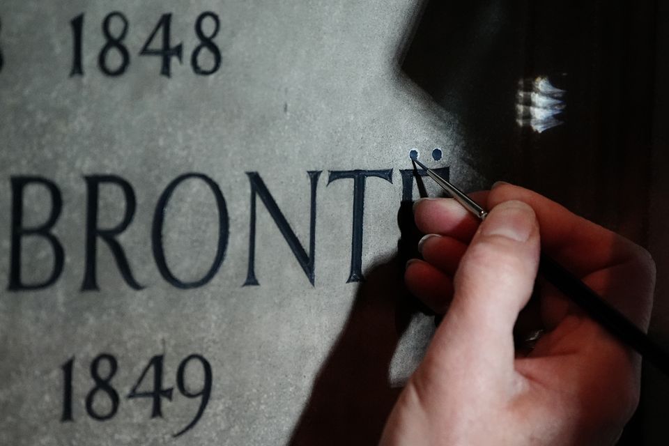 Conservator Lucy Ackland adds the finishing touches to the memorial to Charlotte, Emily and Anne Bronte at Poets’ Corner in Westminster Abbey, London (Aaron Chown/PA)