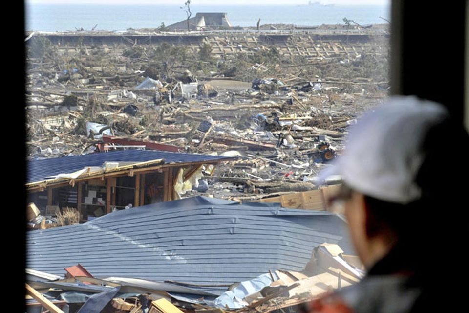A man watches a coastal area from a building where he took shelter in Tamura, Iwate, northern Japan as tsunami warning was issued Monday, March 14, 2011 following Friday's massive earthquake and the ensuing tsunami. (AP Photo/Kyodo News)  JAPAN OUT, MANDATORY CREDIT, NO SALES IN CHINA, HONG  KONG, JAPAN, SOUTH KOREA AND FRANCE
