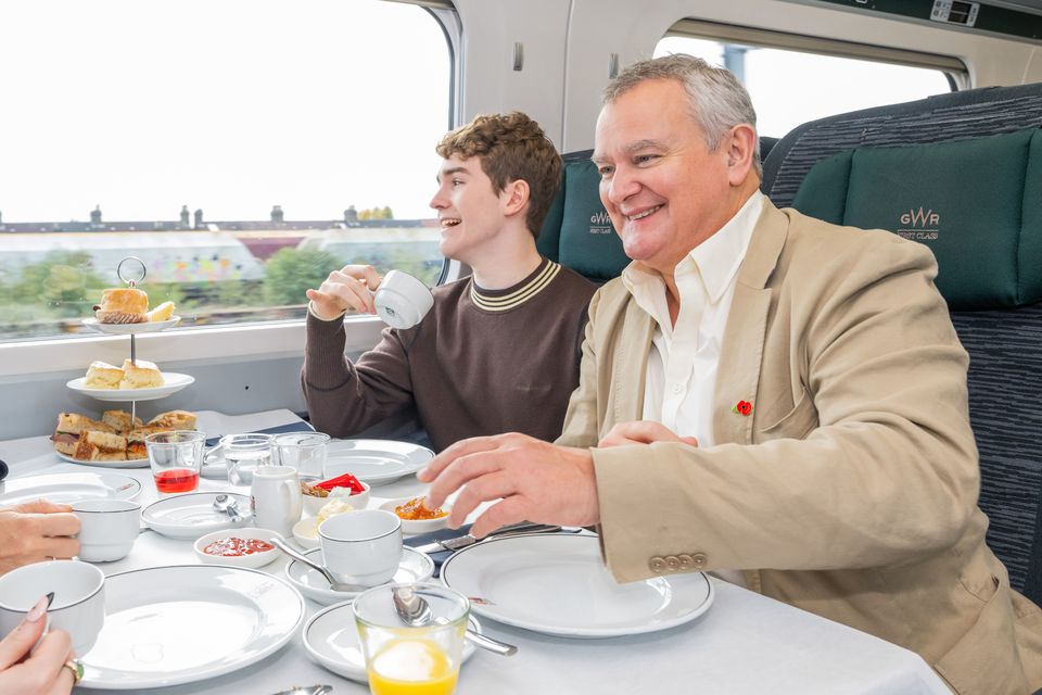 Hugh Bonneville and Samuel Joslin enjoying tea on board the Paddington Peru Express (GWR/PA)