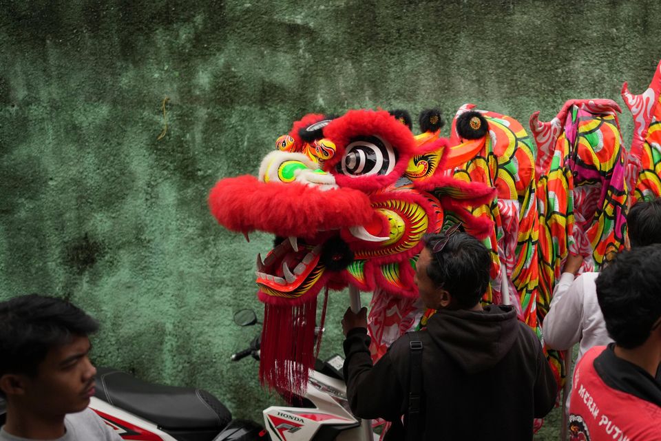 Members of dance club Naga Merah Putih prepare a dragon puppet (Dita Alangkara/AP)