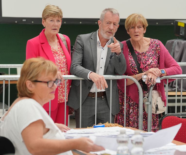 Sean Kelly (centre), alongside his wife Juliette Kelly (left) and her sister Linda O’Donoghue (right), observe as count staff sort ballots at Nemo Rangers GAA club in Cork during the count for the European elections (Jonathan Brady/PA)
