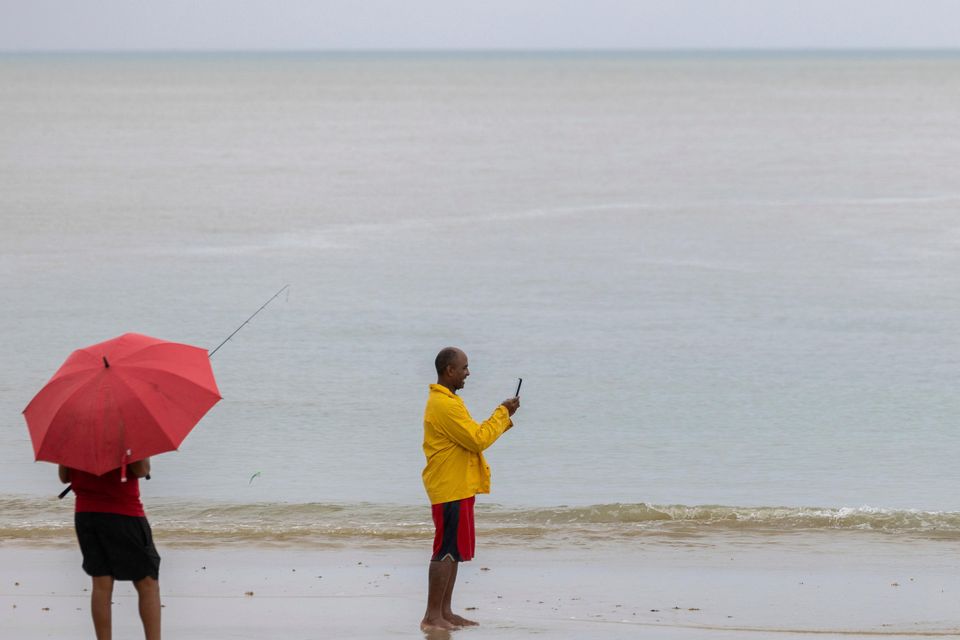 A man poses with a fish after Tropical Storm Ernesto passed through Rio Grande, Puerto Rico (Alejandro Granadillo/AP/PA)