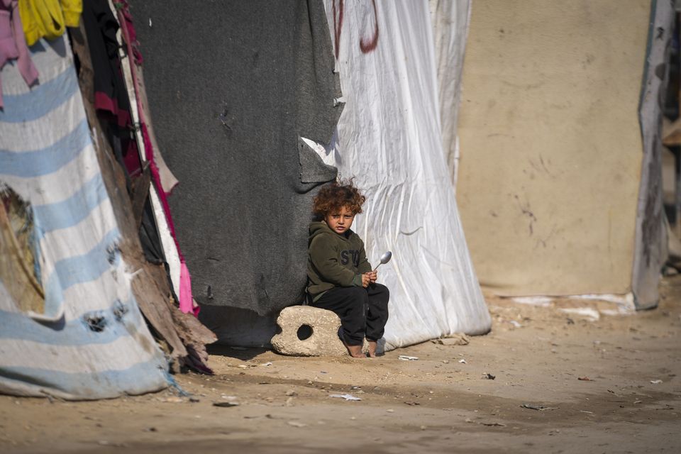 A child sits outside a tent at a camp for displaced Palestinians in Deir al-Balah, central Gaza Strip (Abdel Kareem Hana/AP)