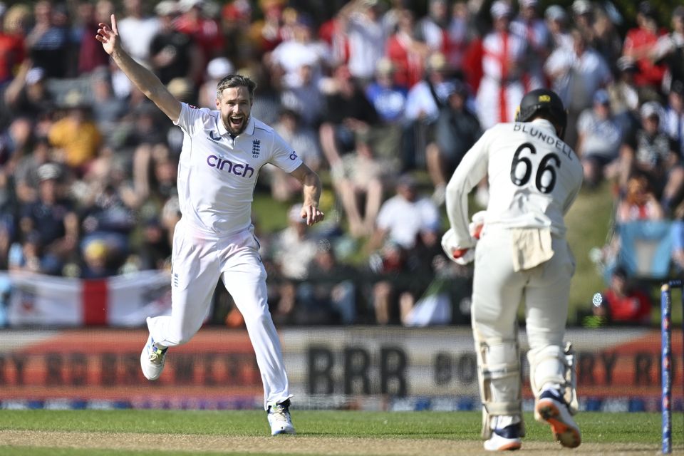 England bowler Chris Woakes runs down the wicket as he celebrates the dismissal of New Zealand batsman Tom Blundell, right (Andrew Cornaga/AP)