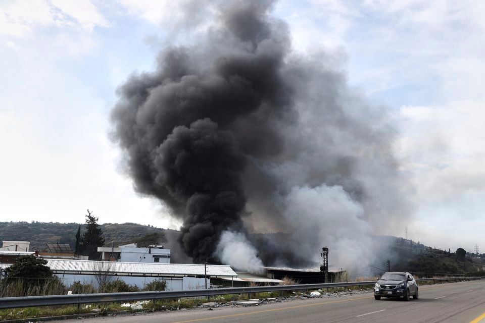 Smoke rises from a factory hit during clashes by Syrian security forces and gunmen loyal to former president Bashar Assad in the outskirts of Latakia, Syria (AP)