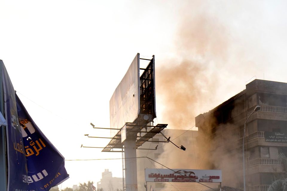 People pass buildings destroyed by Israeli air strike in Dahiyeh, Beirut, Lebanon (Hussein Malla/AP)