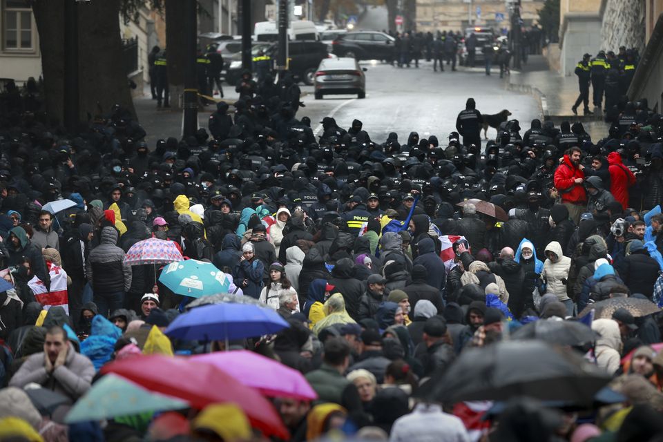 Police block protesters gathered in a street near the Parliament building in Tbilisi during a rally to demand new elections in Georgia (Zurab Tsertsvadze/AP)