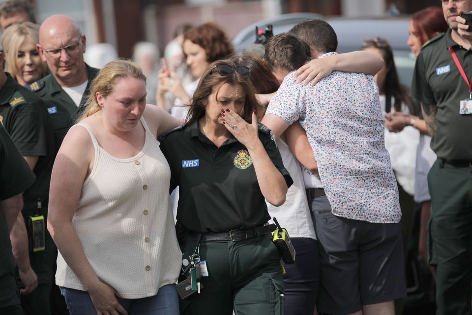 Emergency personnel and members of the public pay their respects at the scene of the attack (James Speakman/PA)