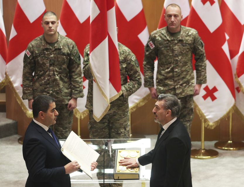 President-elect Mikheil Kavelashvili, right, takes the oath during his swearing-in ceremony at the Georgian parliament in Tbilisi (Irakli Gedenidze/Pool/AP)