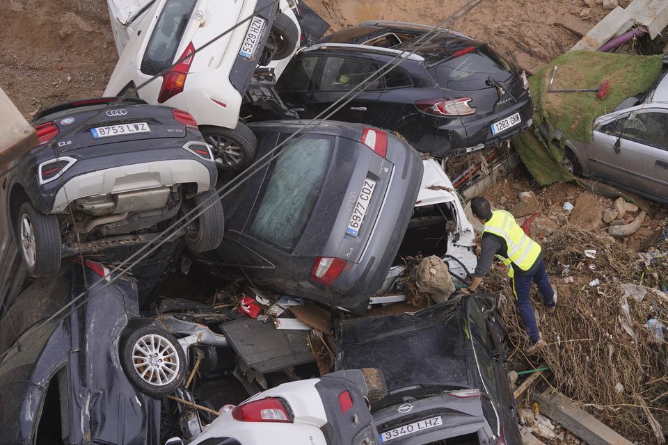 A civil guard searches for survivors in cars (Alberto Saiz/AP)