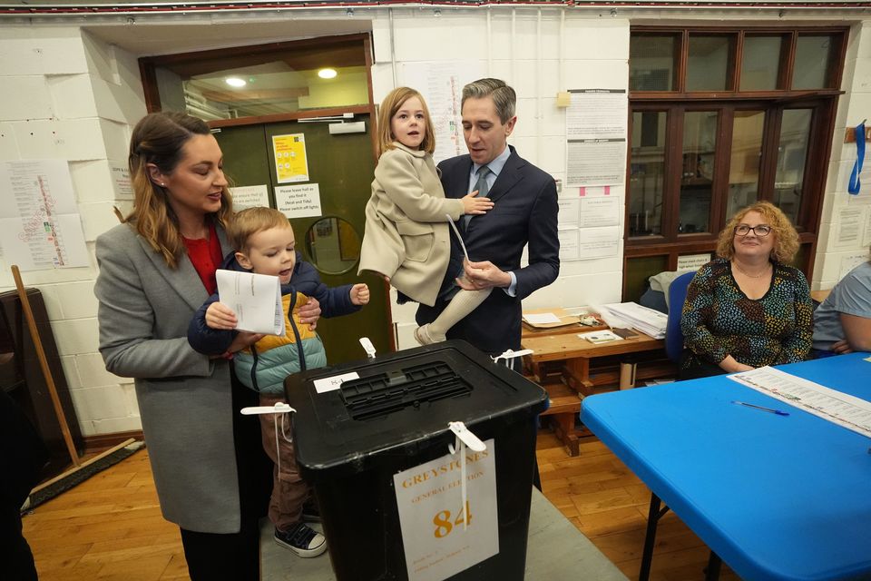 Taoiseach and Fine Gael leader Simon Harris, with his wife Caoimhe and children Cillian and Saoirse, casts his vote (Niall Carson/PA)