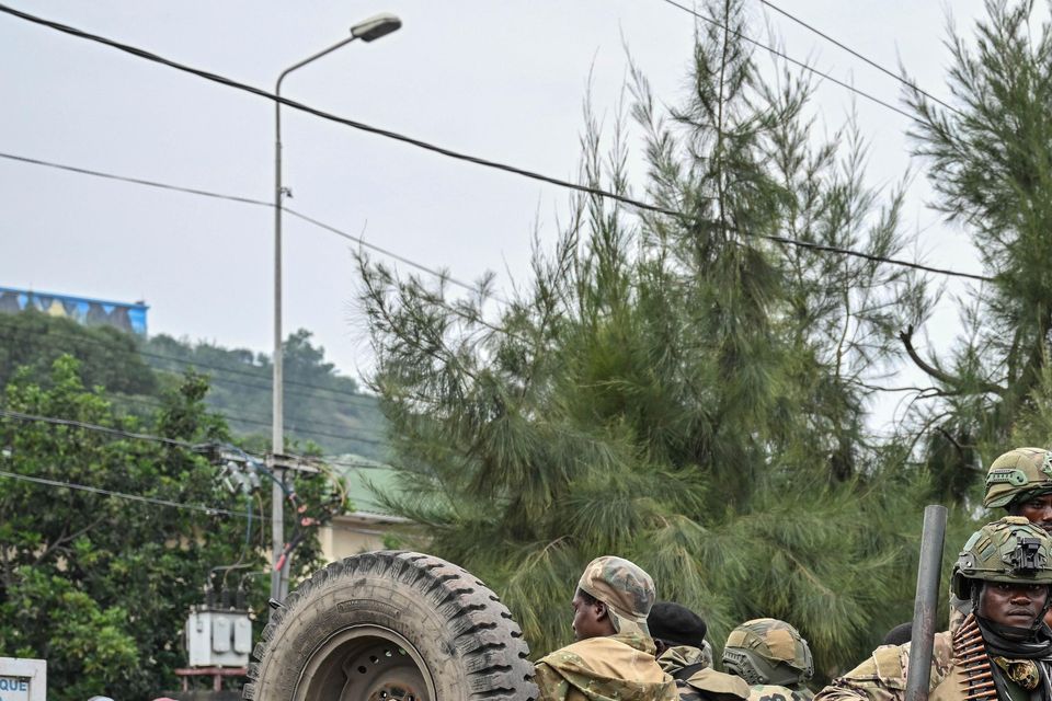 M23 rebels escort government soldiers and police (Moses Sawasawa/AP)