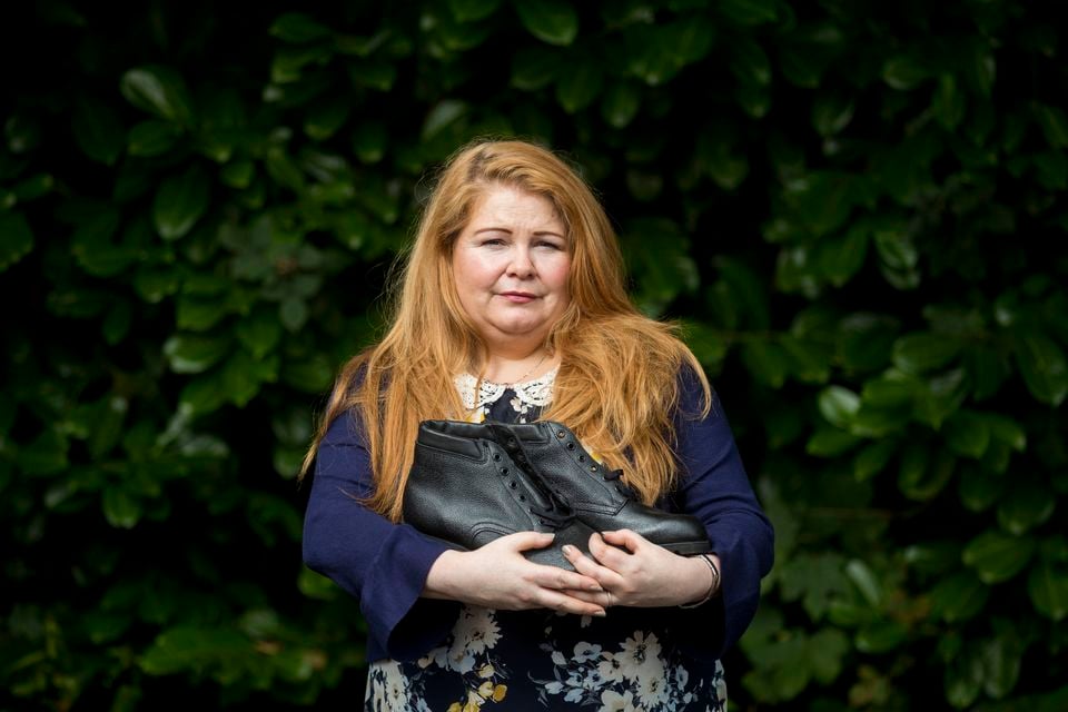 Cat Wilkinson, daughter of Michael Gallagher, holding her brother Aiden’s work boots which he bought on the day of the Omagh bomb (PA)