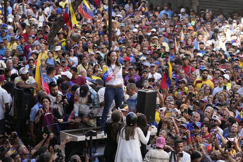 Opposition leader Maria Corina Machado stands before supporters during a protest against Mr Maduro (Ariana Cubillos/AP)