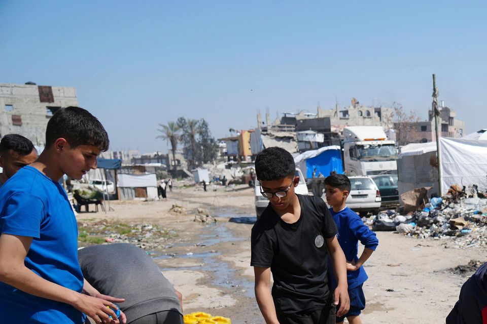 Palestinians fill cans with water in Jabaliya, northern Gaza Strip (AP Photo/Abdel Kareem Hana)