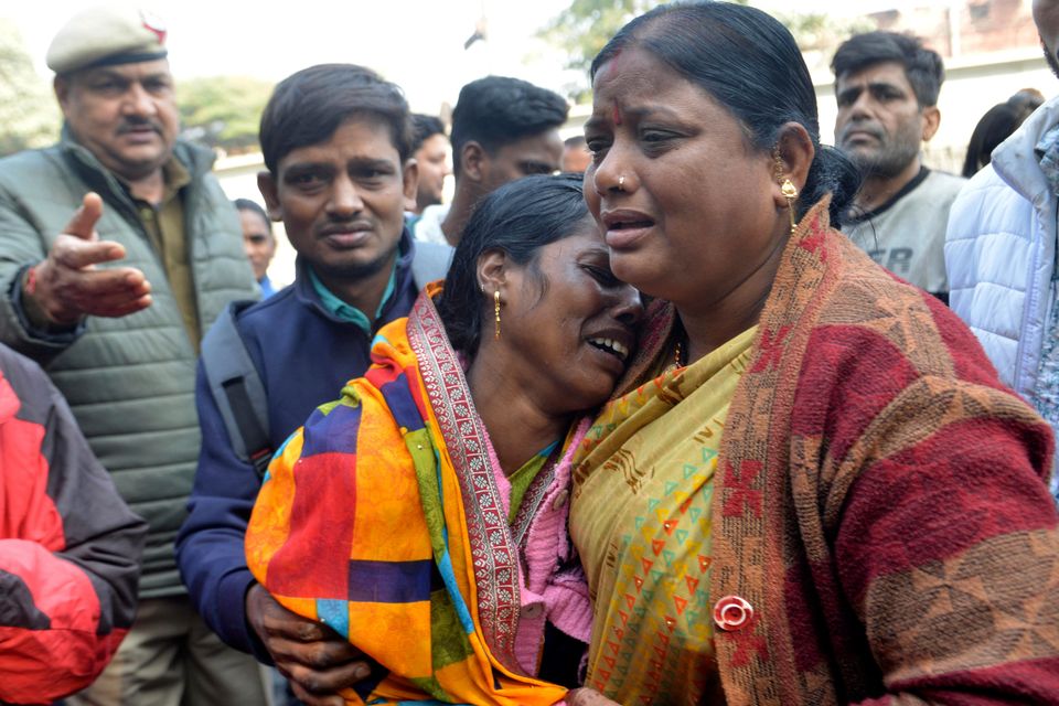 Relatives of a passenger who died during a stampede at New Delhi railway station console each other as they wait to collect the body from a hospital (AP Photo)