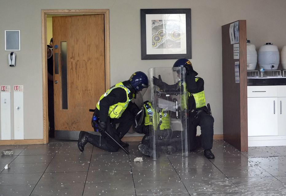 Police tend to a wounded colleague inside the hotel (Danny Lawson/PA)