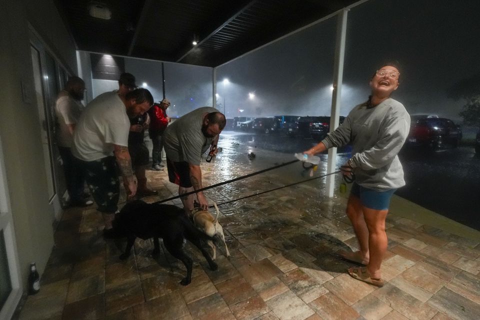 Amy Sapanara reacts as a group of tow truck drivers from Georgia greet her dogs outside the hotel where they are taking shelter during Hurricane Milton (Julio Cortez/AP)