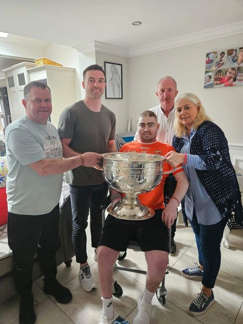 Caolan and his family, pictured alongside Armagh captain Aidan Forker with Sam Maguire