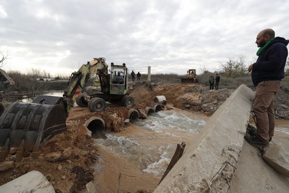 Workers repair a bridge over the Assi river in Qusair, Syria (Omar Sanadiki/AP)