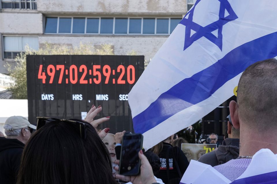 Israelis watch a live broadcast from the Gaza Strip during a gathering at Hostages square (Oded Balilty/AP)