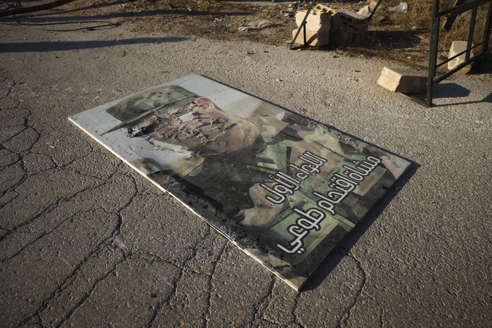 A defaced portrait of Syrian President Bashar Assad lies on the ground in the town of Maarat al-Numan, south-west of Aleppo (Omar Albam/AP)