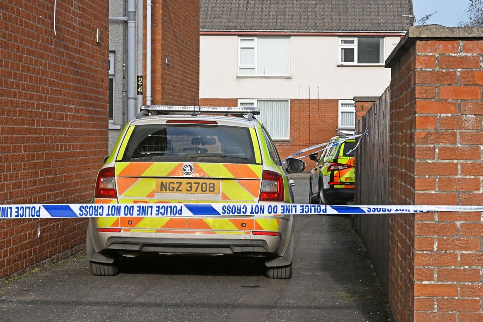 Police vehicles are outside a flat in the Rush Park area. (Alan Lewis)