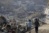 thumbnail: A couple walk along the rubble at a residential area in Onagawa, Miyagi Prefecture, northern Japan, Sunday, March 13, 2011, two days after a powerful earthquake-triggered tsunami hit the country's east coast. (AP Photo/The Yumiuri Shimbun) JAPAN OUT, CREDIT MANDATORY