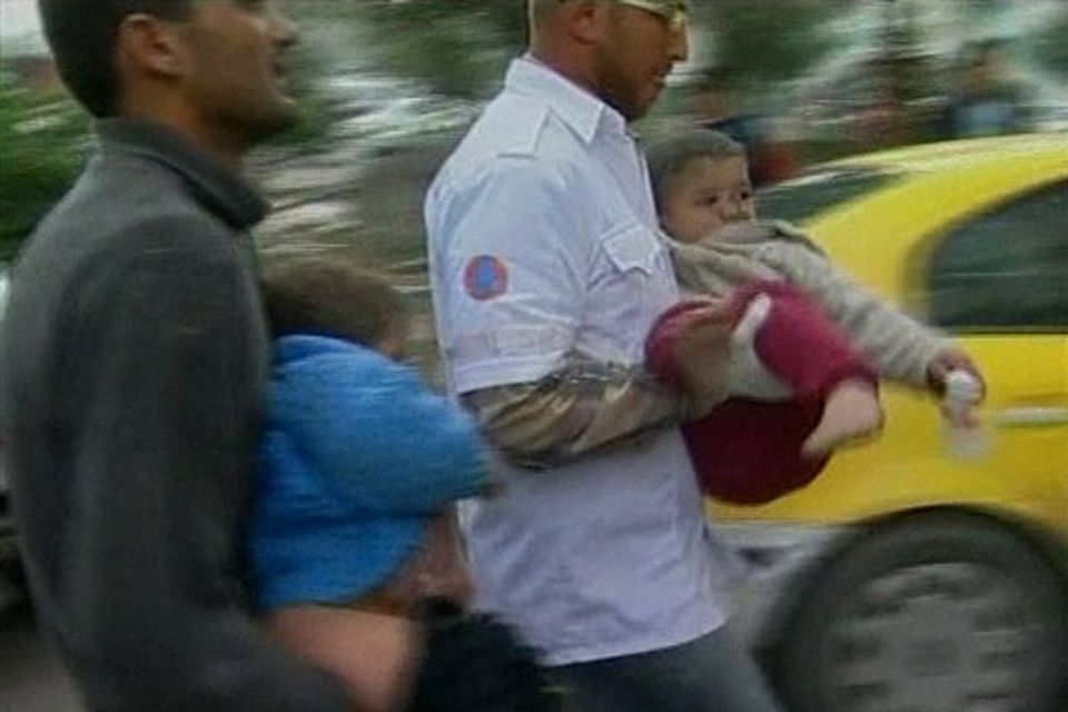 In this image taken from APTN video, Palestinian men carry two injured children into hospital after Israeli aircraft struck Hamas security compounds across Gaza in Gaza City on Saturday Dec. 27, 2008. Hamas and medics reported that dozens of people were killed and that others were still buried under the rubble. The strikes caused widespread panic and confusion, as black clouds of smoke rose above Gaza. (AP Photo/APTN)