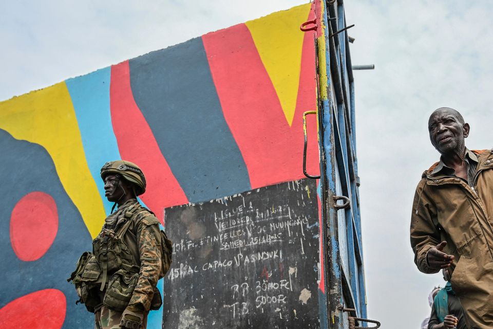 Government soldiers and police officers, at right, who surrendered to M23 rebels, left, board trucks to an undisclosed location in Goma (Moses Sawasawa/AP)