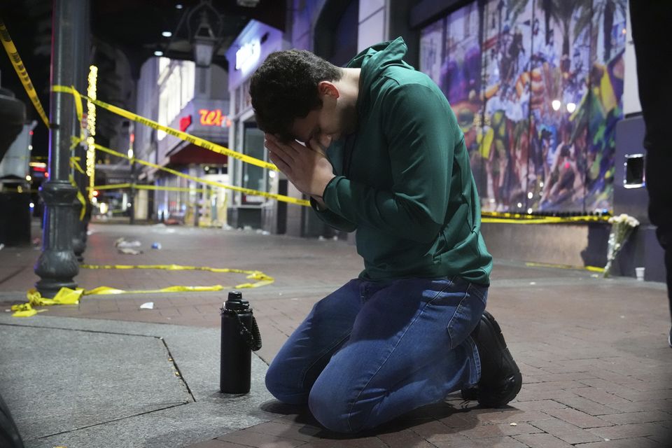 Matthias Hauswirth of New Orleans prays on the street near the scene (George Walker/AP)