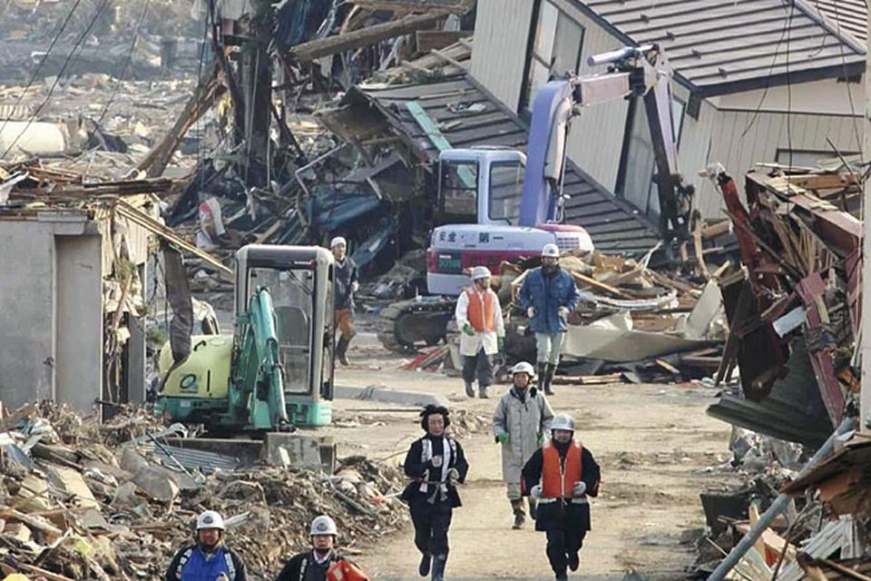 Rescue workers run through rubble for the higher place in Rikuzentakata in Iwate Prefecture, northeastern Japan, upon hearing a tsunami warning Sunday, March 13, 2011, two days after a powerful earthquake-triggered tsunami hit the country's east coast. (AP Photo/The Yumiuri Shimbun) JAPAN OUT, CREDIT MANDATORY