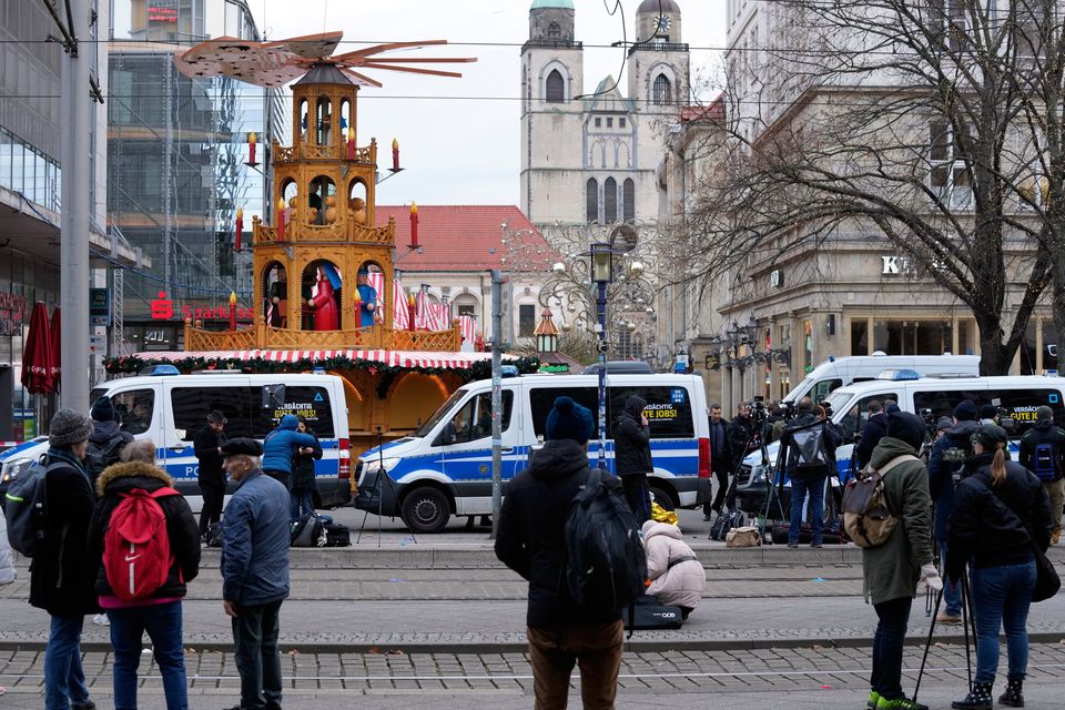 Journalists stand by a cordoned-off area near the Christmas Market in Magdeburg. (AP Photo/Michael Probst)