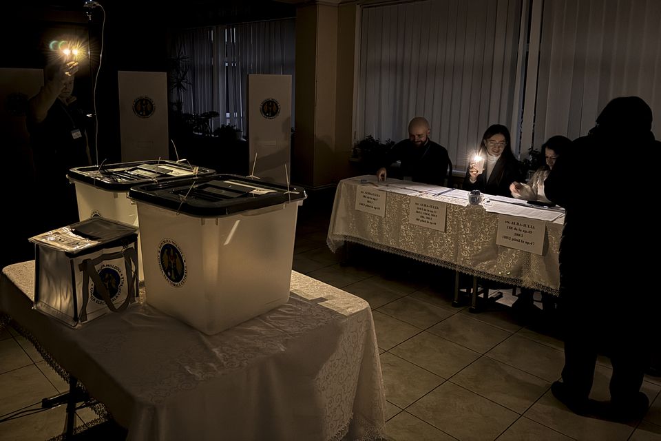 Election officials use mobile phone torches to help voters during a power failure at a polling station in Chisinau, Moldova (Nicolae Dumitrache/AP)