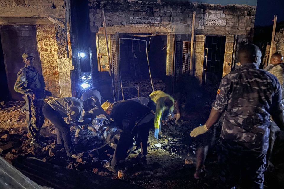 Uganda forensic officials inspect the site where the fuel truck exploded (AP)