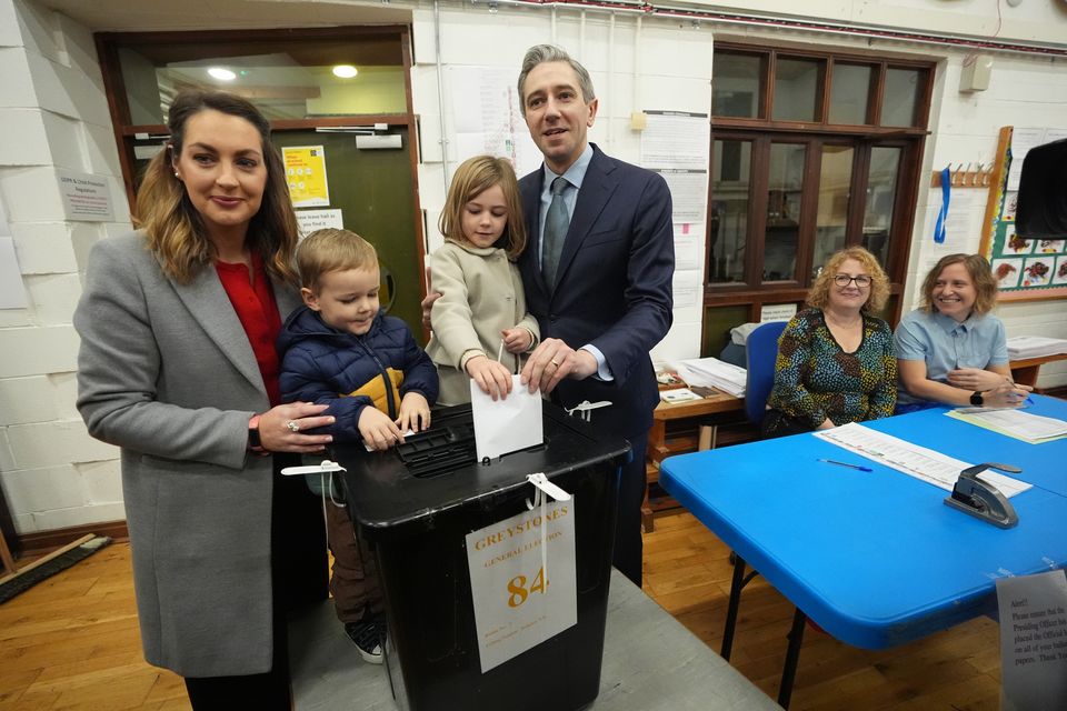 Taoiseach and Fine Gael leader Simon Harris and his wife, Caoimhe, cast their votes at Delgany National School, County Wicklow, with their children (Niall Carson/PA)