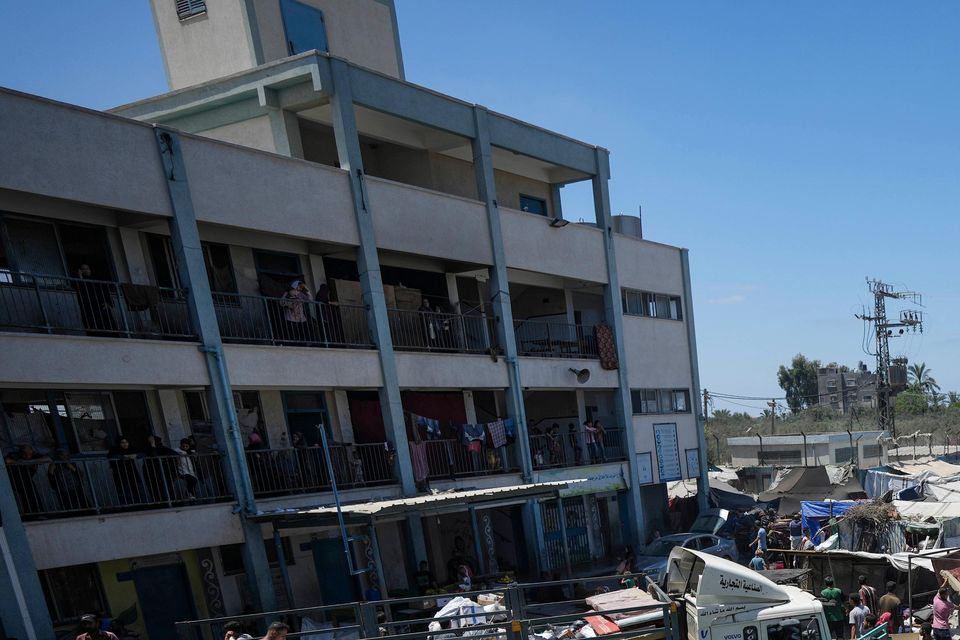 Palestinians evacuate a school that had been their shelter, in eastern Deir al-Balah, after the Israeli military dropped leaflets asking civilians to evacuate (Abdel Kareem Hana/AP)