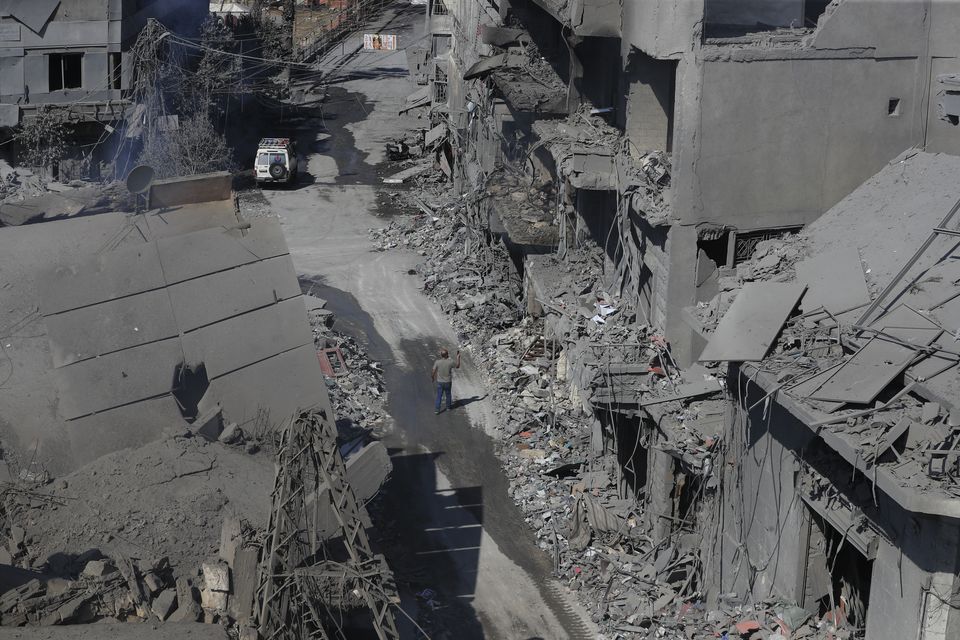 A man walks amid destroyed buildings in the town of Nabatiyeh, south Lebanon, following Israeli air strikes on Saturday night (Mohammed Zaatari/AP)