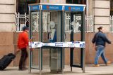 thumbnail: Members of the public walk past phone boxes taped shut by police ahead of the state visit to Ireland by the Queen